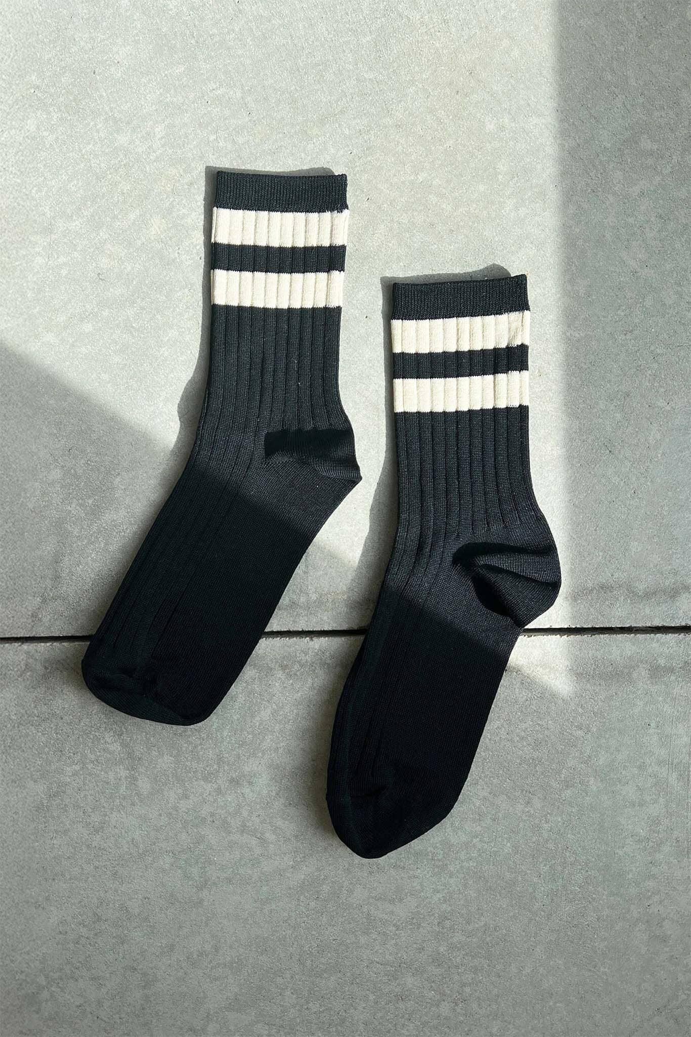 Black socks with white stripes on a gray surface