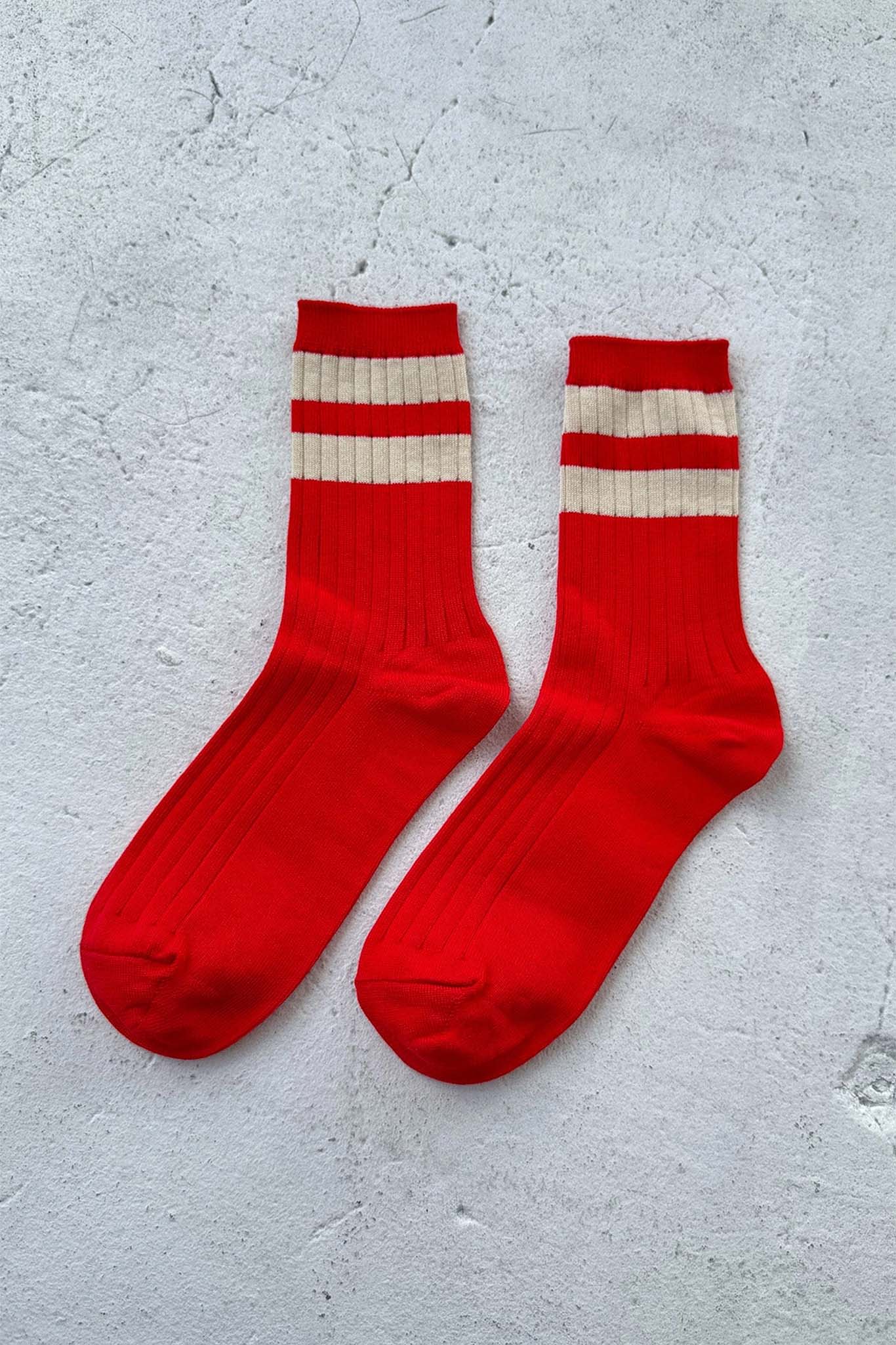 Red socks with white stripes on a gray surface