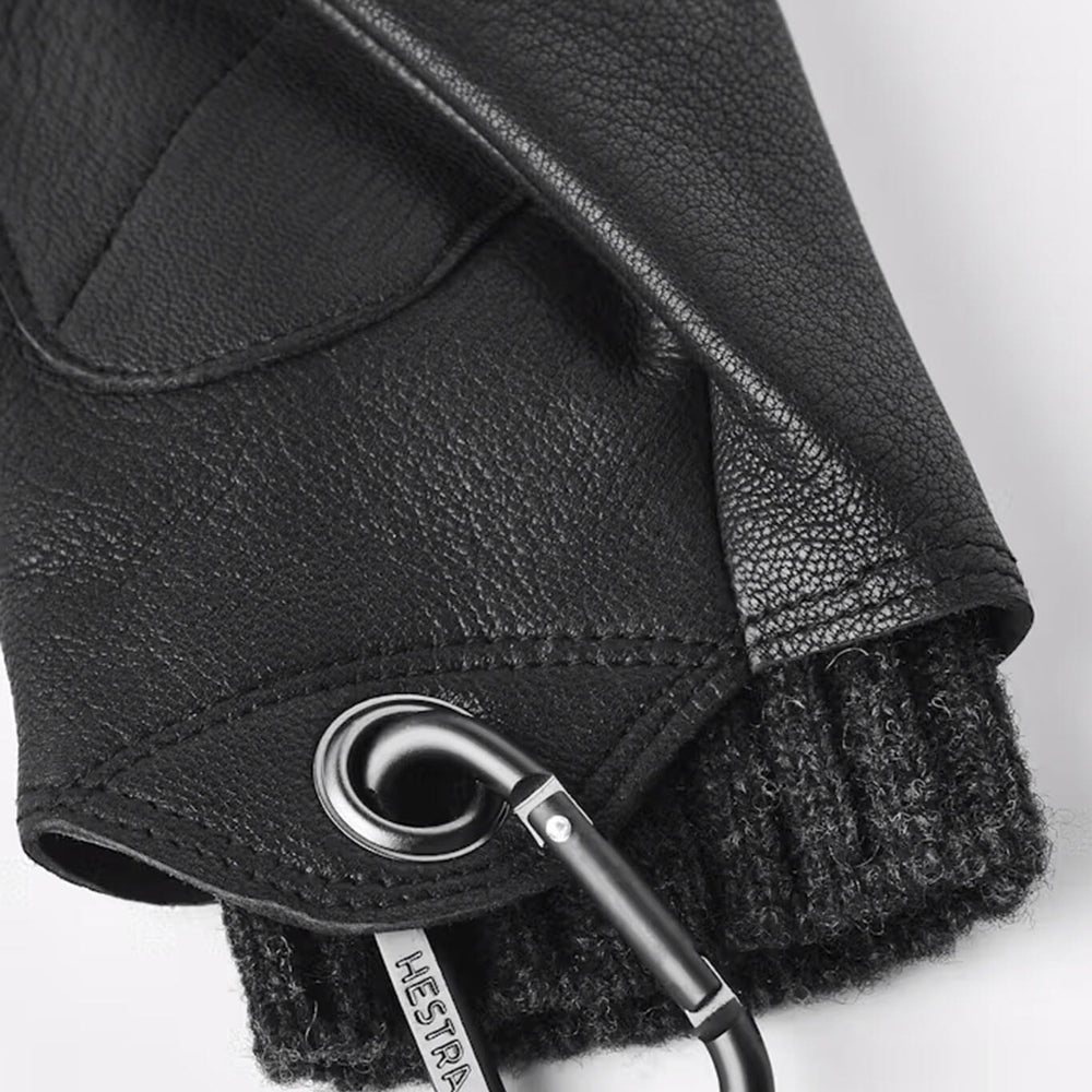 A close up of women's insulated black leather gloves with a carabiner 