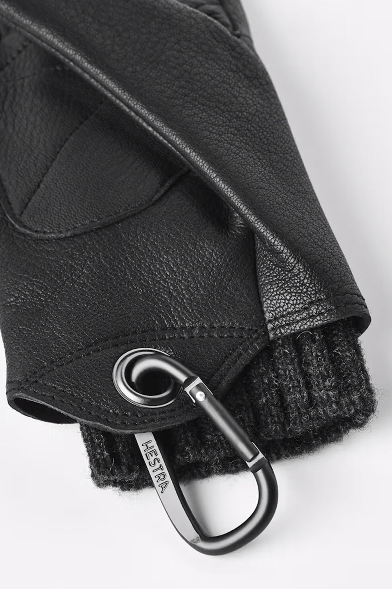 A close up of women's insulated black leather gloves with a carabiner 