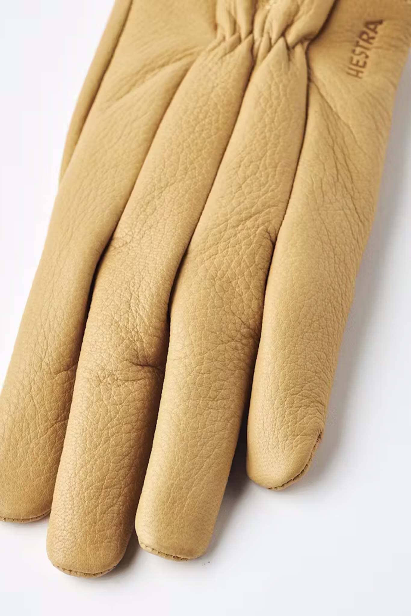 Tan leather glove on a white background