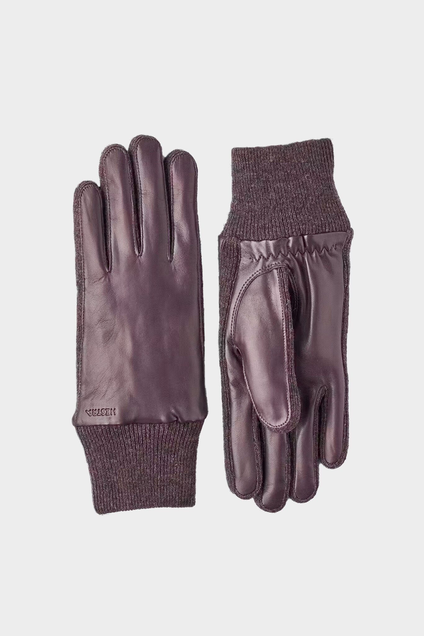 Pair of leather gloves with knit cuffs on a light gray background