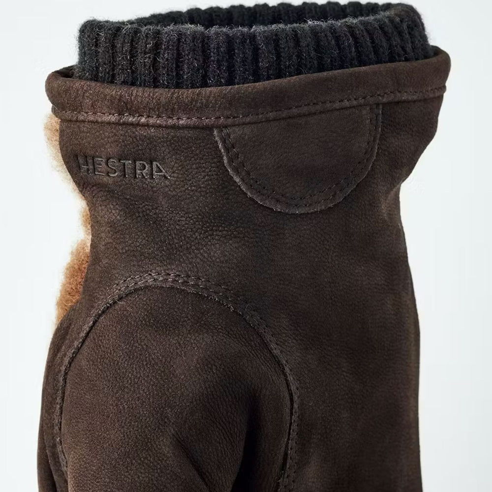 Brown leather and wool glove with black ribbed collar on a white background