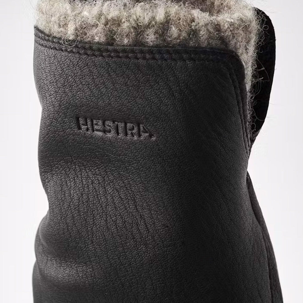 Women's black wool lined mittens showcasing the "HESTRA" logo