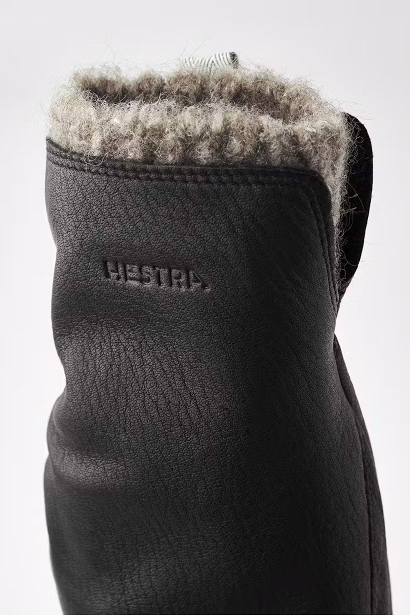 Women's black wool lined mittens showcasing the "HESTRA" logo