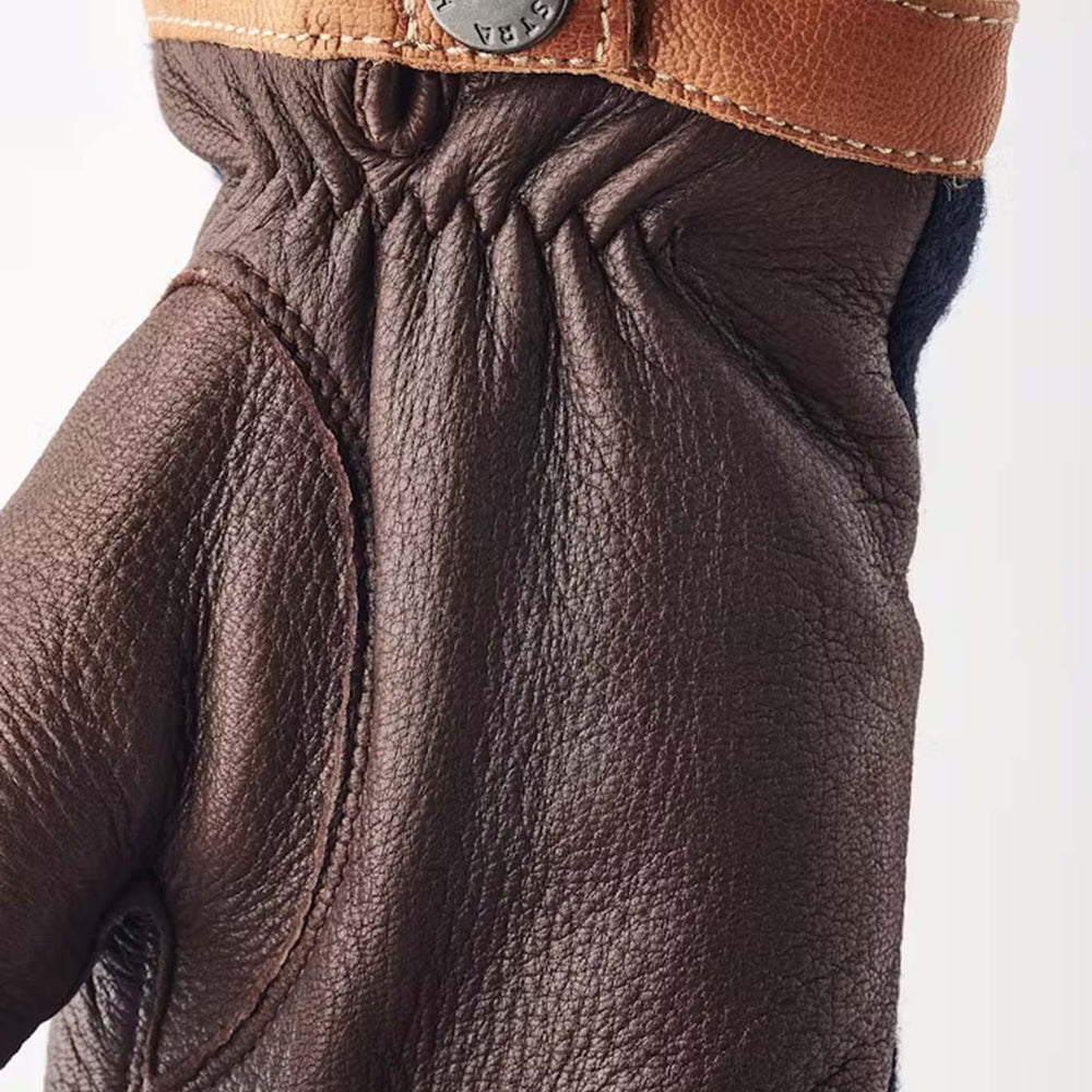 Close up of Hestra Tricot Deerskin glove with a tan hemline with silver button