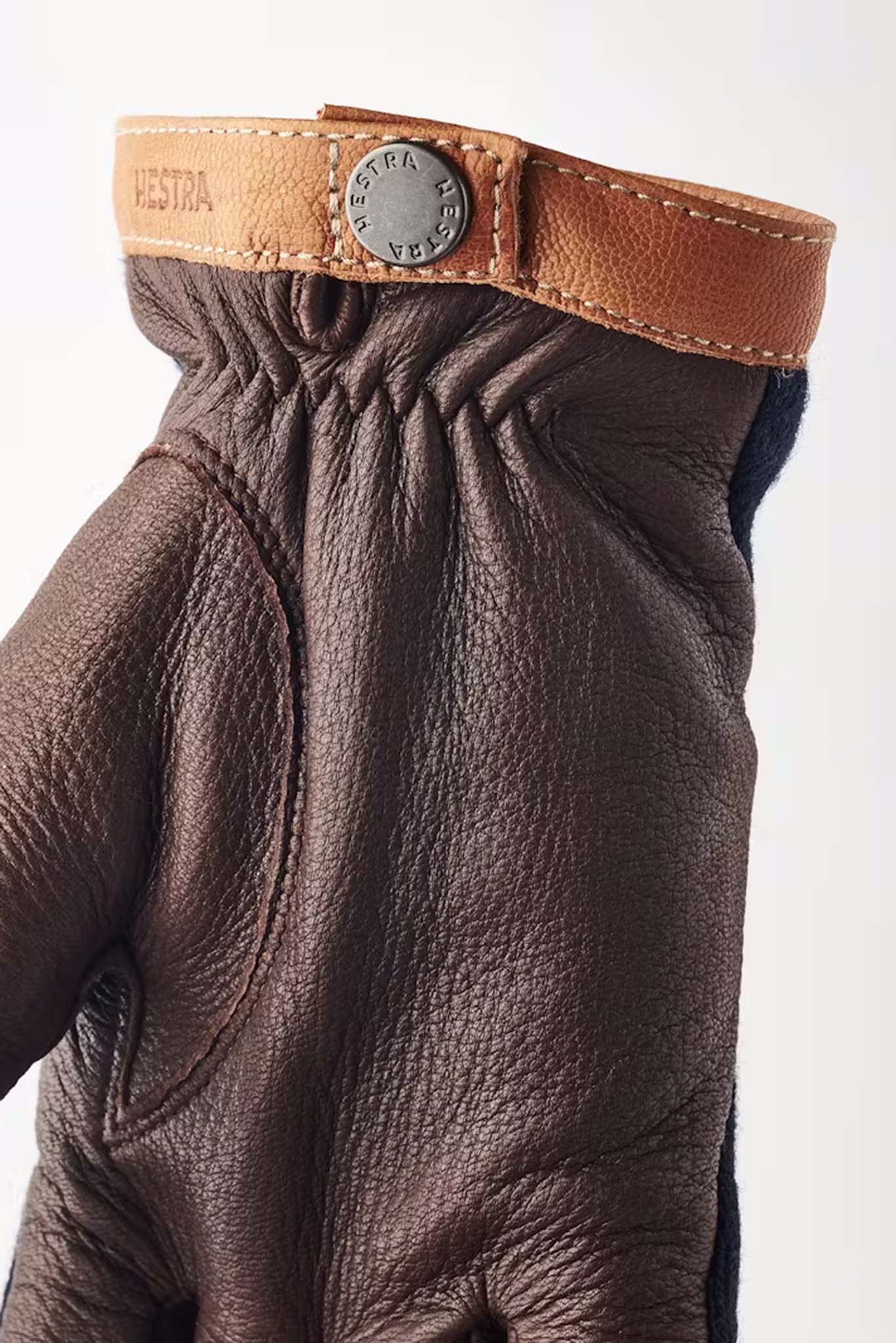Close up of Hestra Tricot Deerskin glove with a tan hemline with silver button