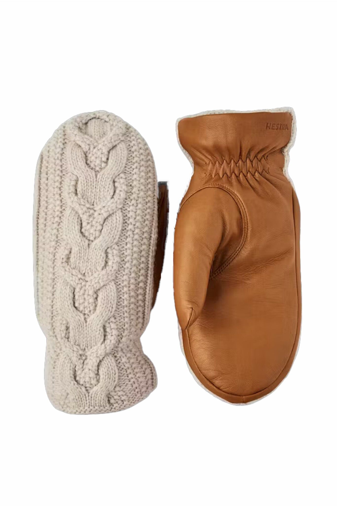 Pair of mittens, one beige knitted and one brown leather, on a white background