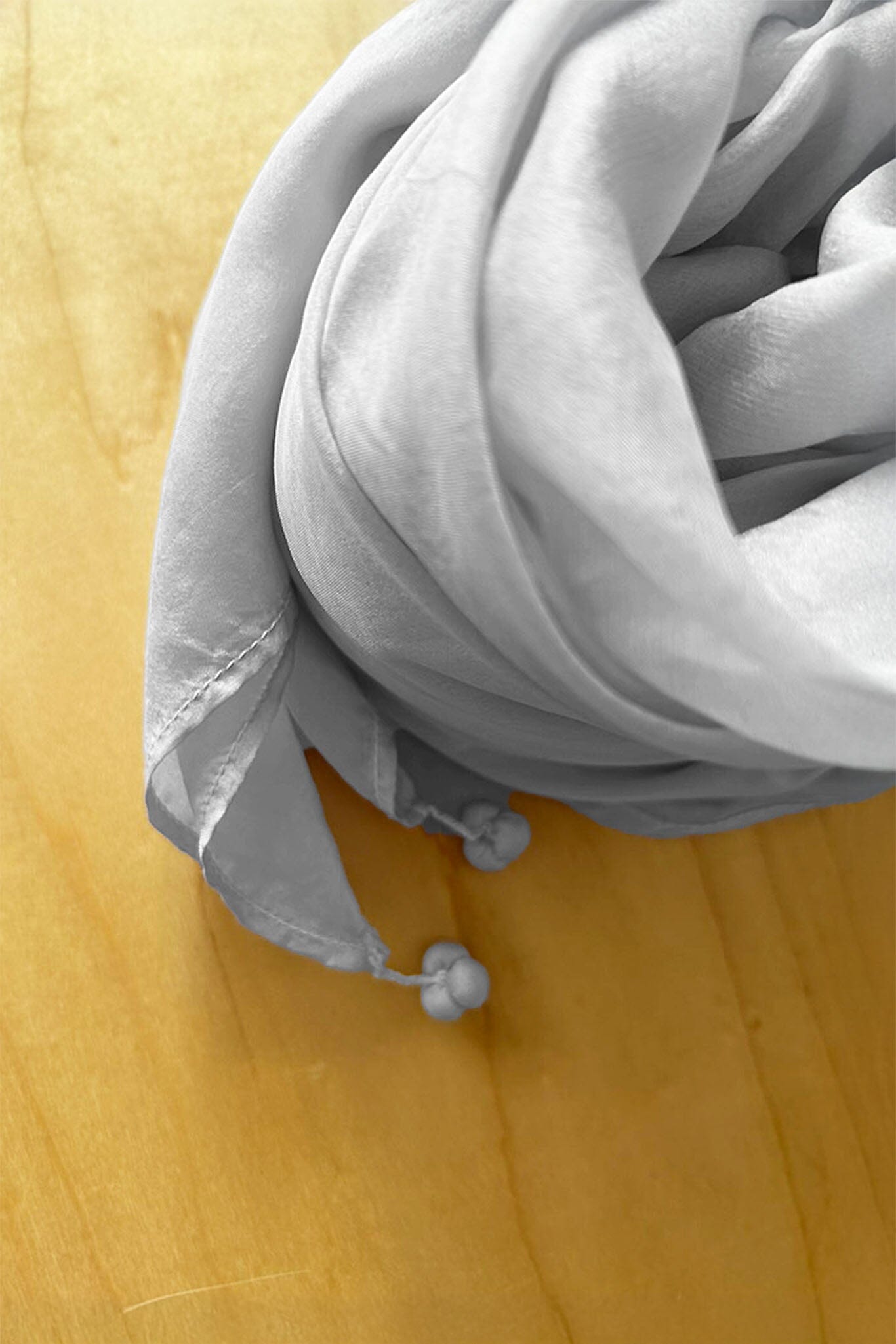 tassels on the edge of a silver grey silk scarf