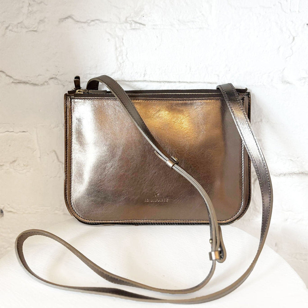 Metallic bronze crossbody bag on a light marble background