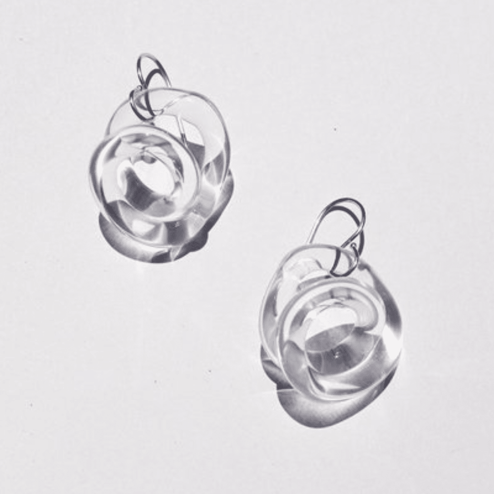 A pair of clear glass squiggle hoops with a silver fish hook ear wire.