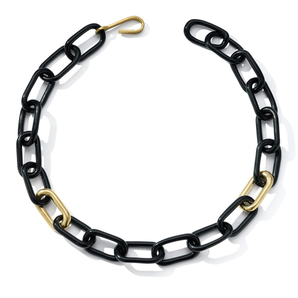 A black oval glass link necklace with two brass links and a brass closure.