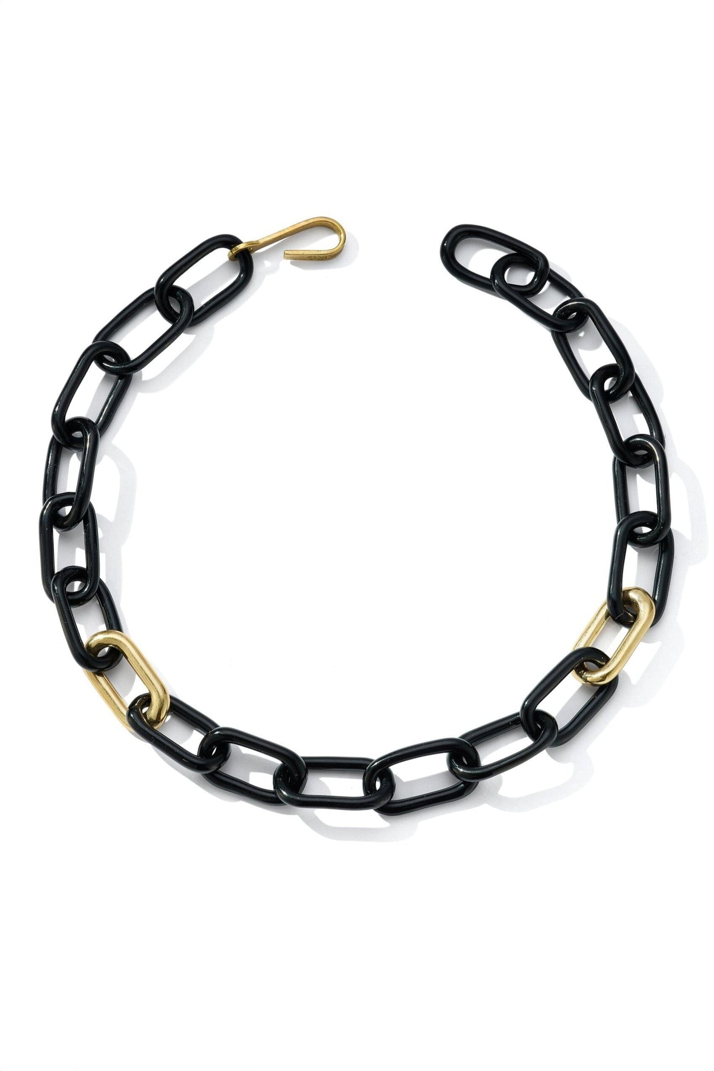 A black oval glass link necklace with two brass links and a brass closure.