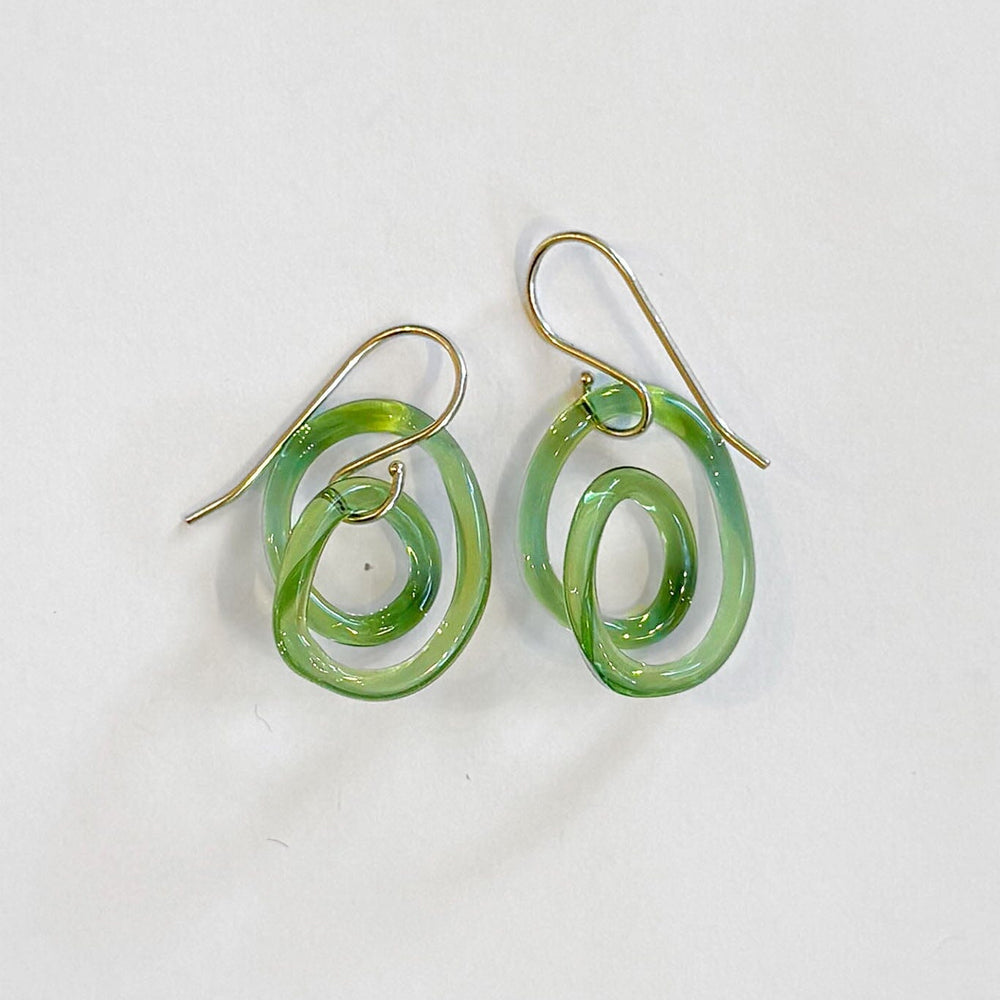 Green glass spiral earrings on a white background