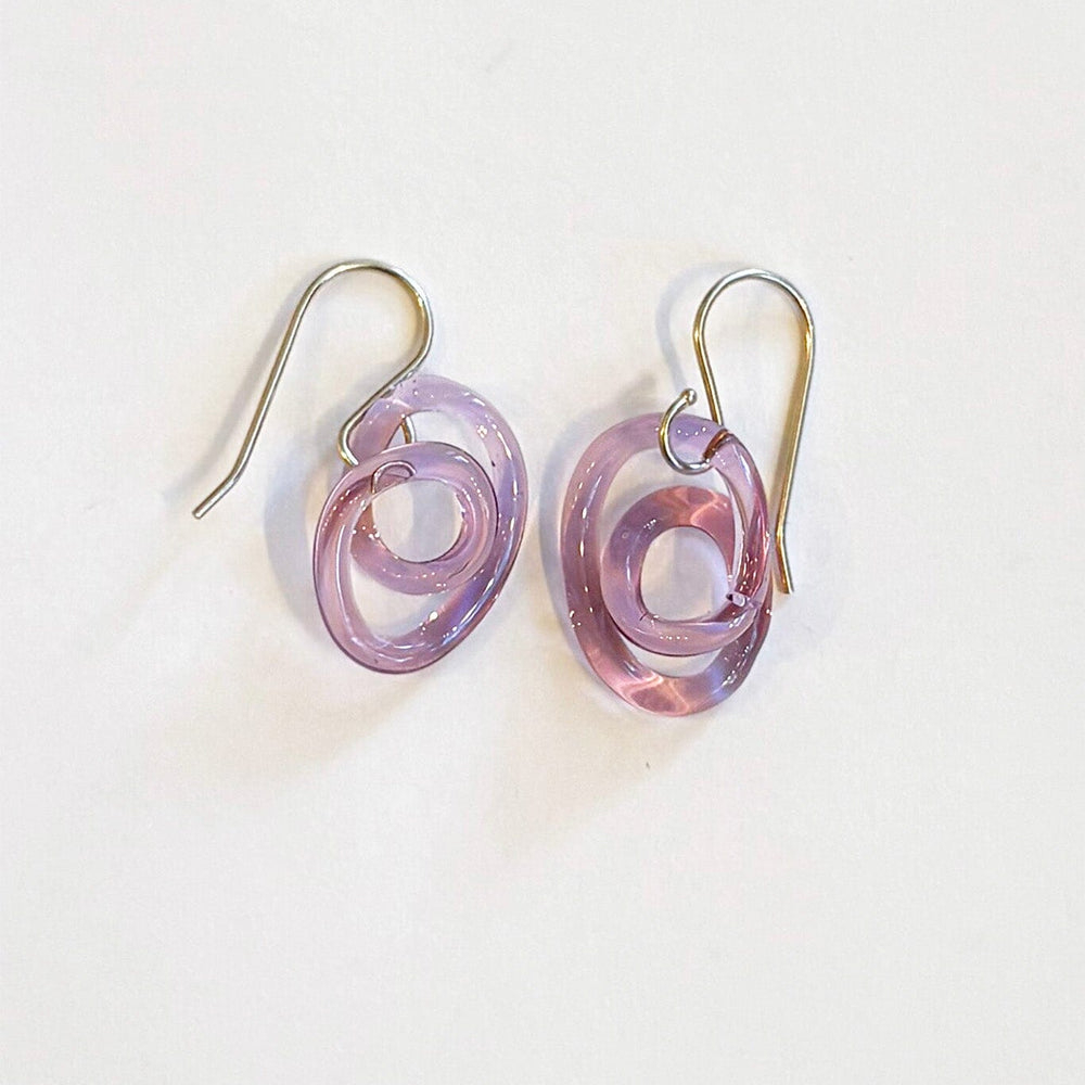 Pair of purple glass spiral earrings on a white background