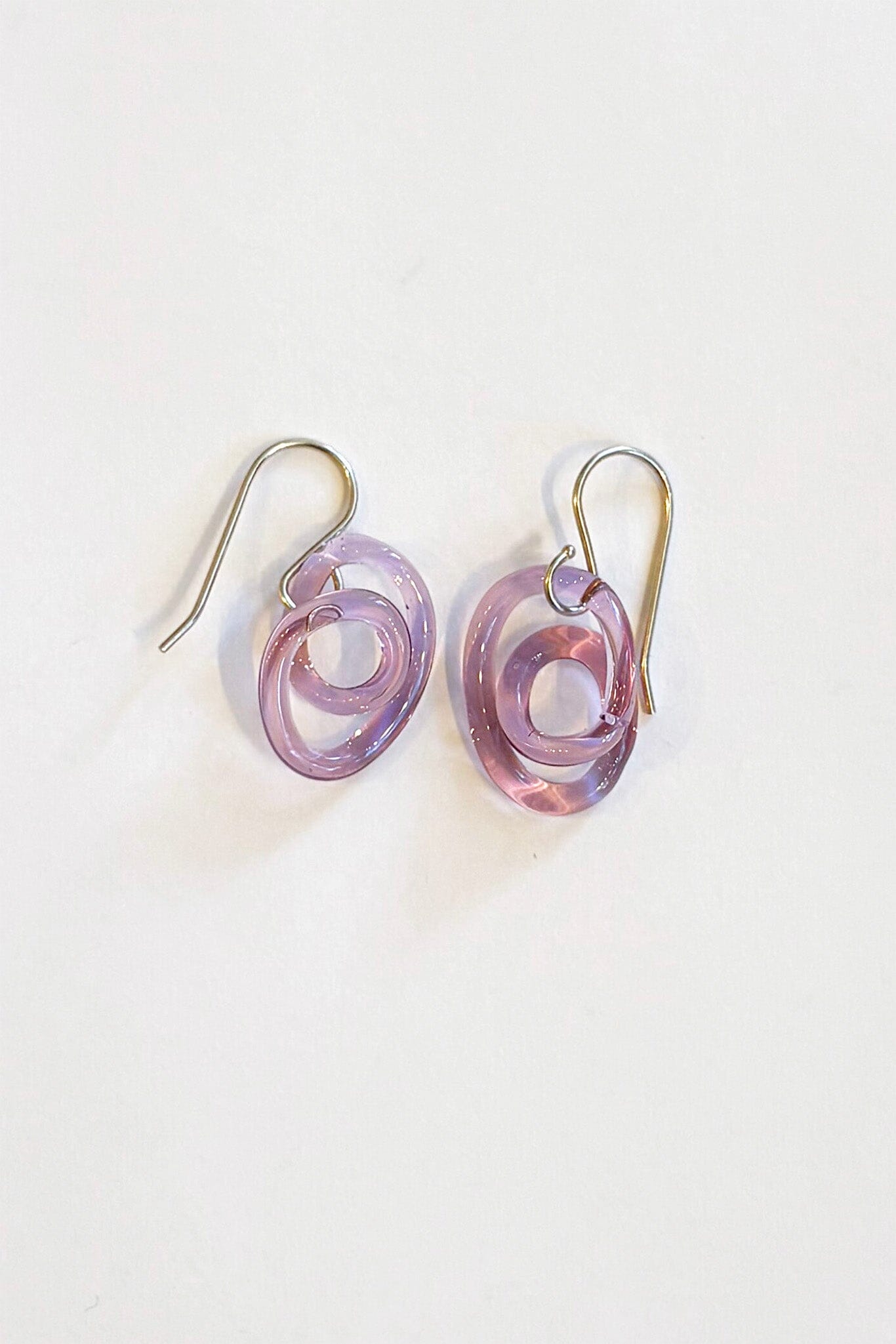 Pair of purple glass spiral earrings on a white background
