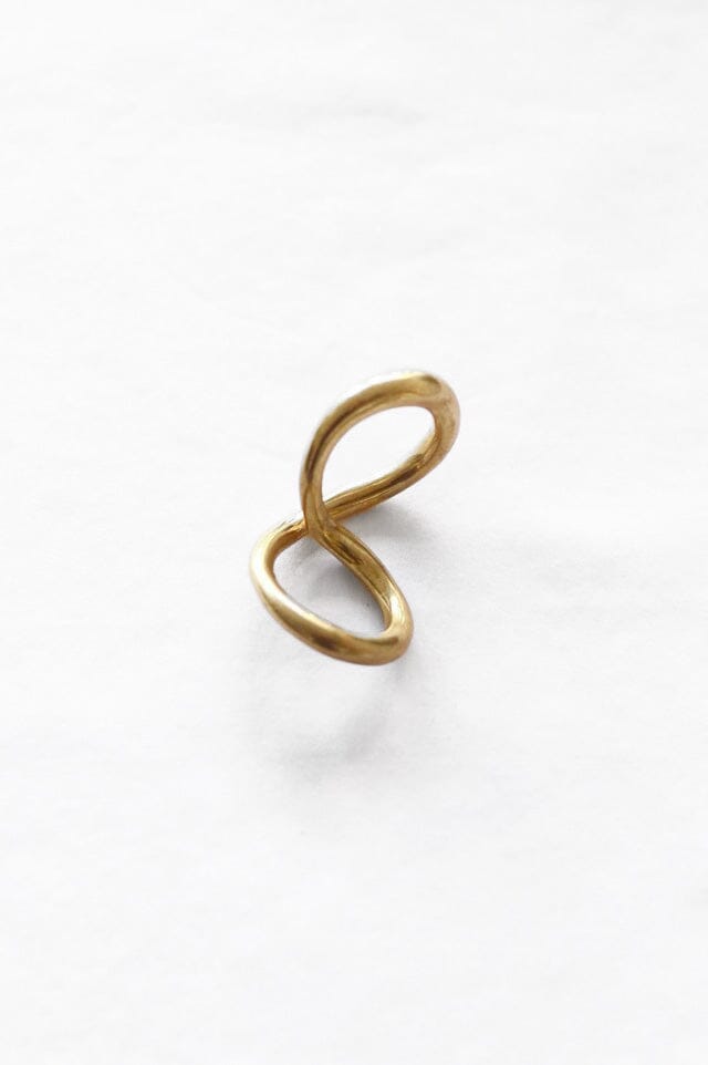 An organic brass ring with a mobius twist design, displayed against a white background.