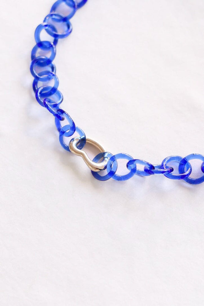 A blue glass chain link necklace with a silver pendent