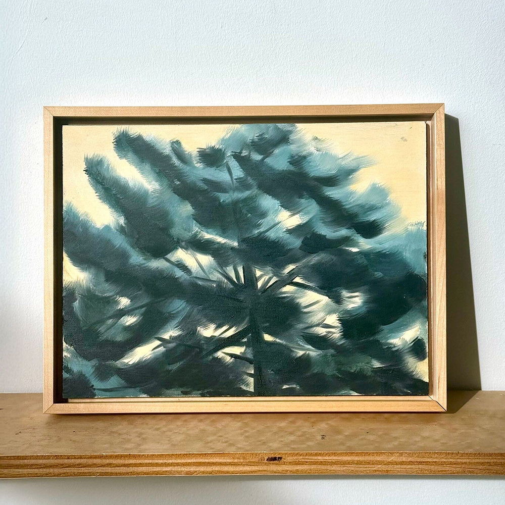 Framed artwork of a teal abstract design on a white wall