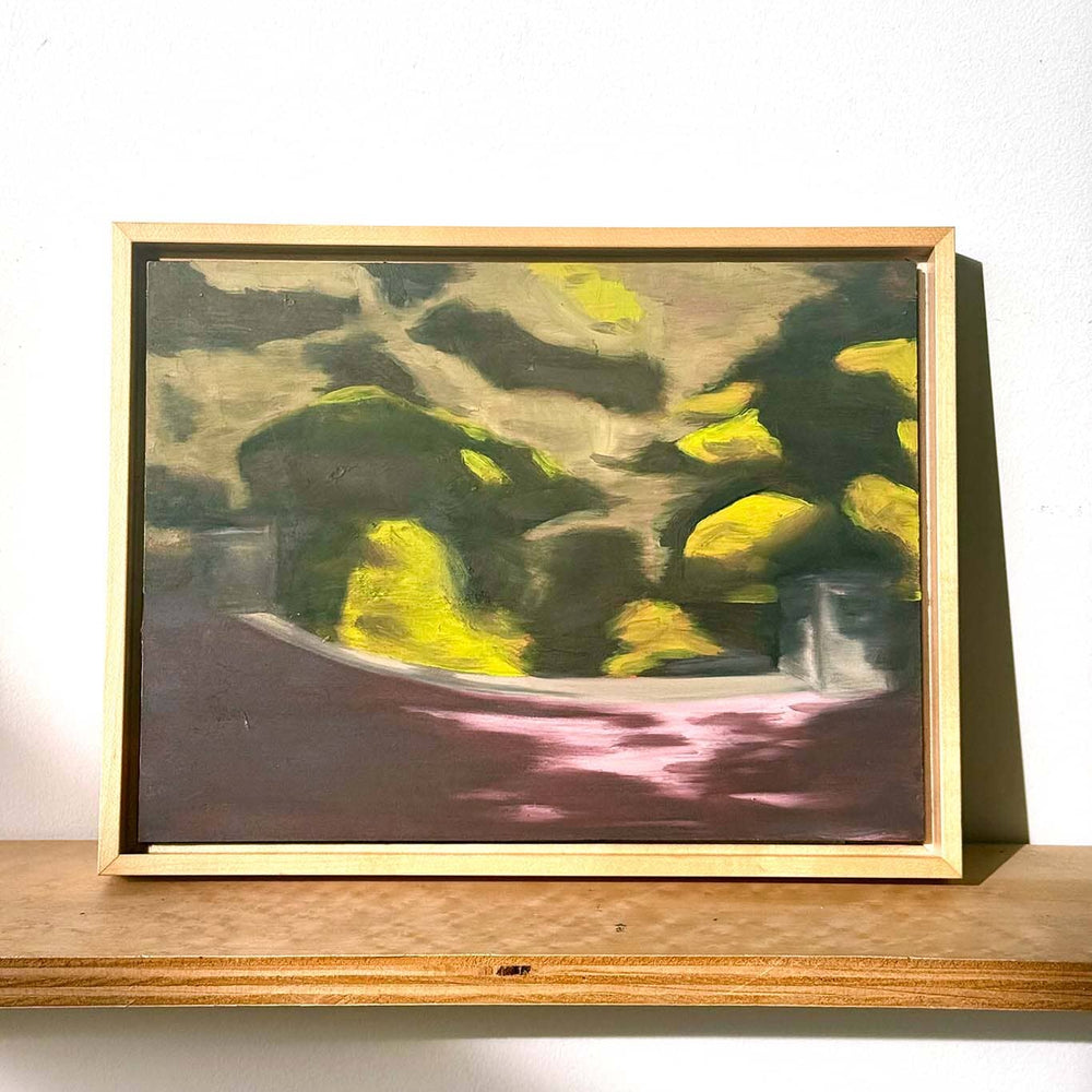 Framed abstract painting on a wooden shelf with a white background