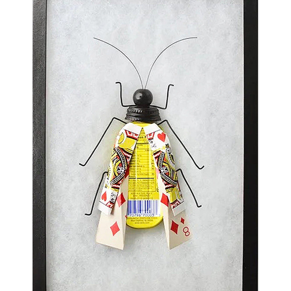 Framed artwork of a paper insect with playing card wings on a white background