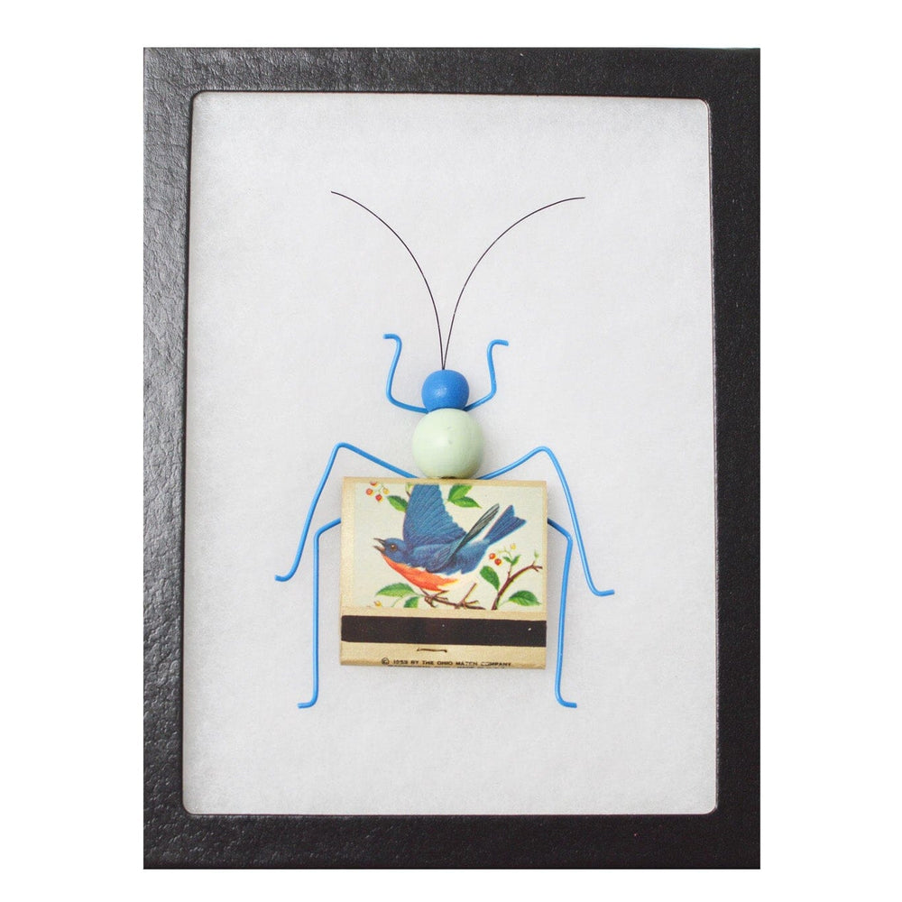 Framed artwork of a blue bug made from matches on a white background