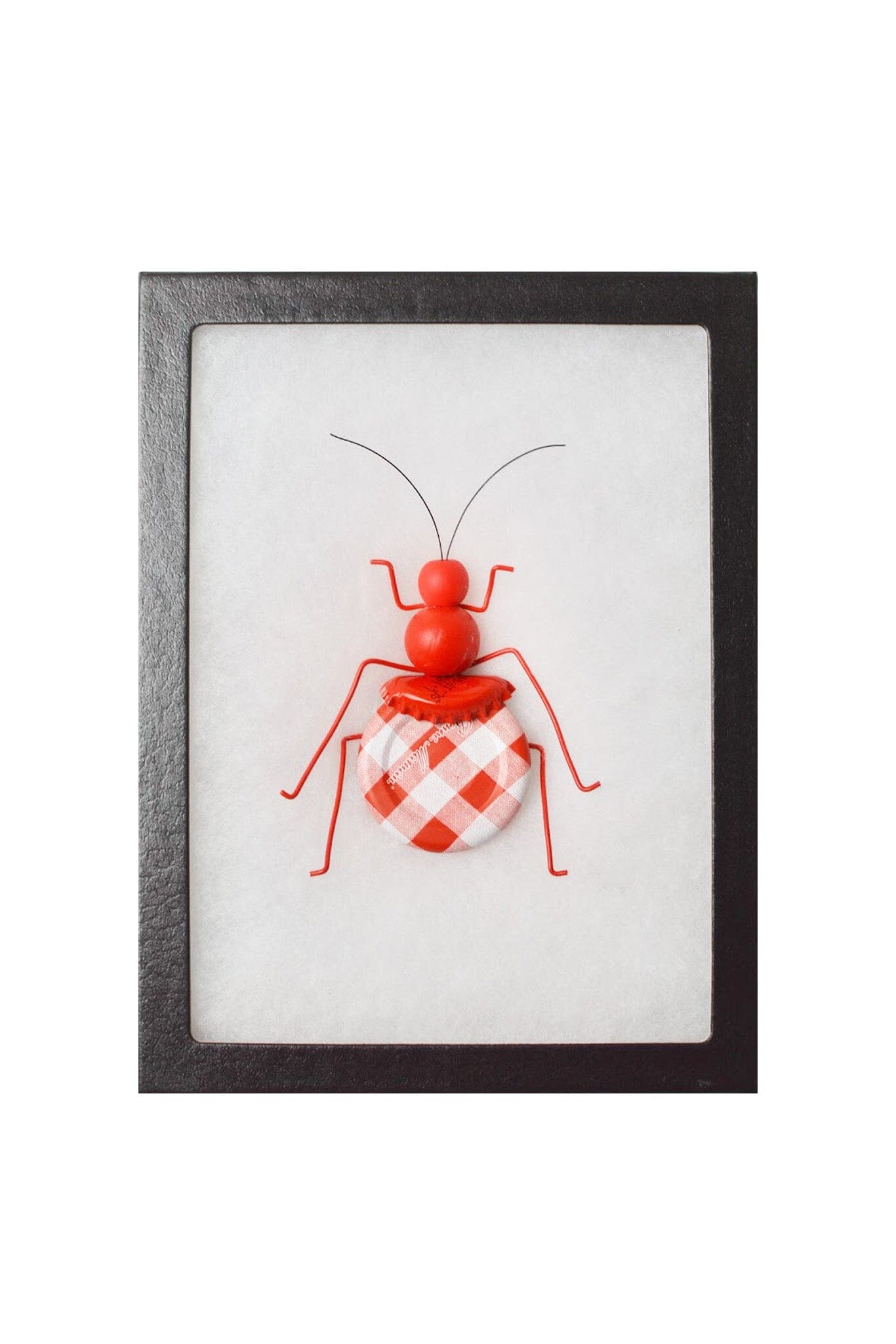 Framed artwork of a red and white checkered ant on a white background