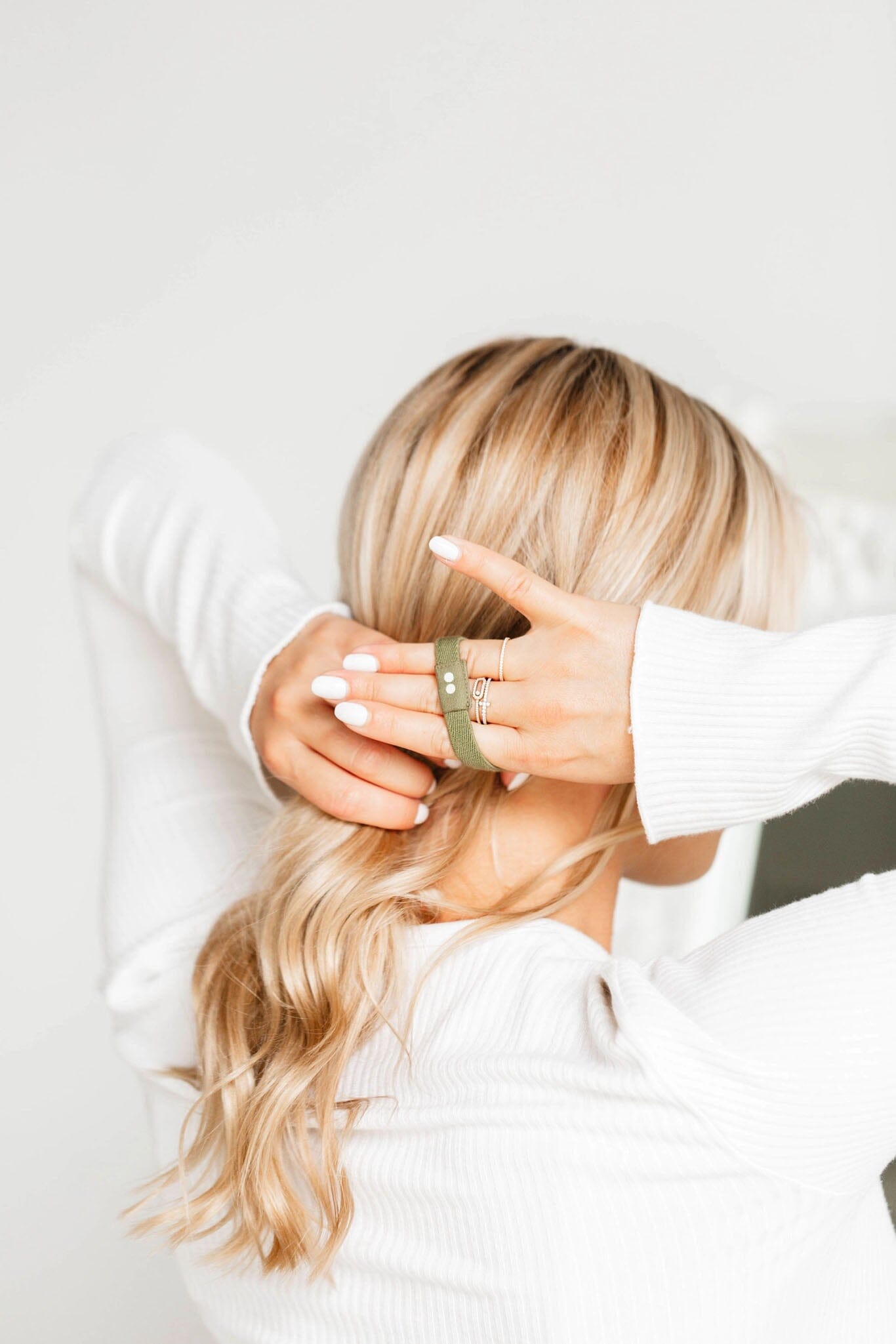 Person with blonde hair wearing a green headband against a white background
