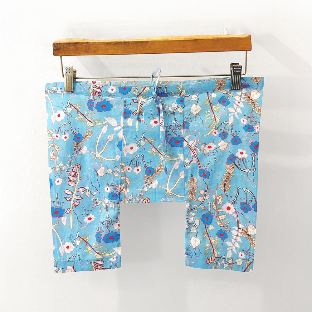 Children's blue floral pajama bottoms on a hanger against a white background