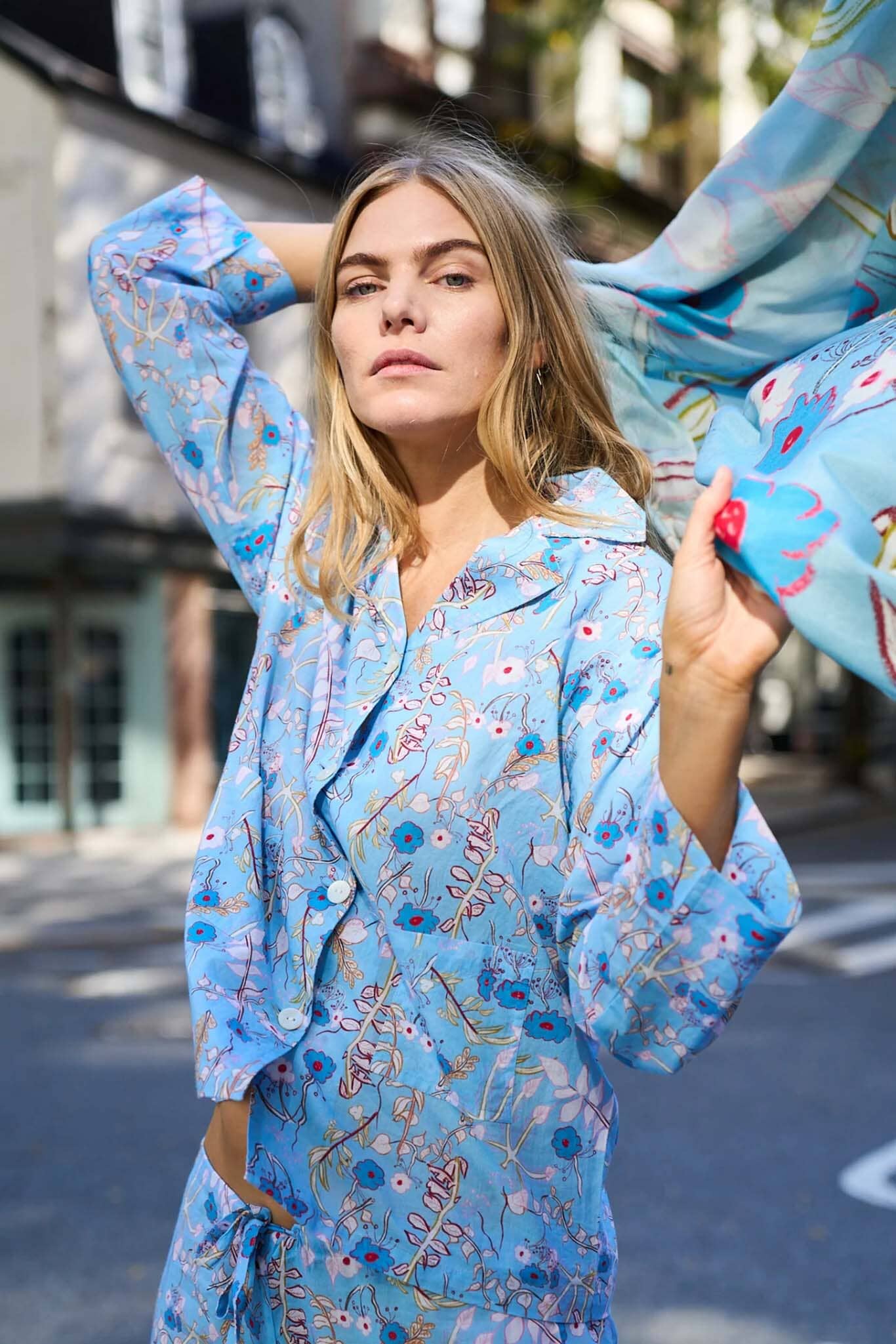 A woman wears blue, long sleeve floral cotton pajamas