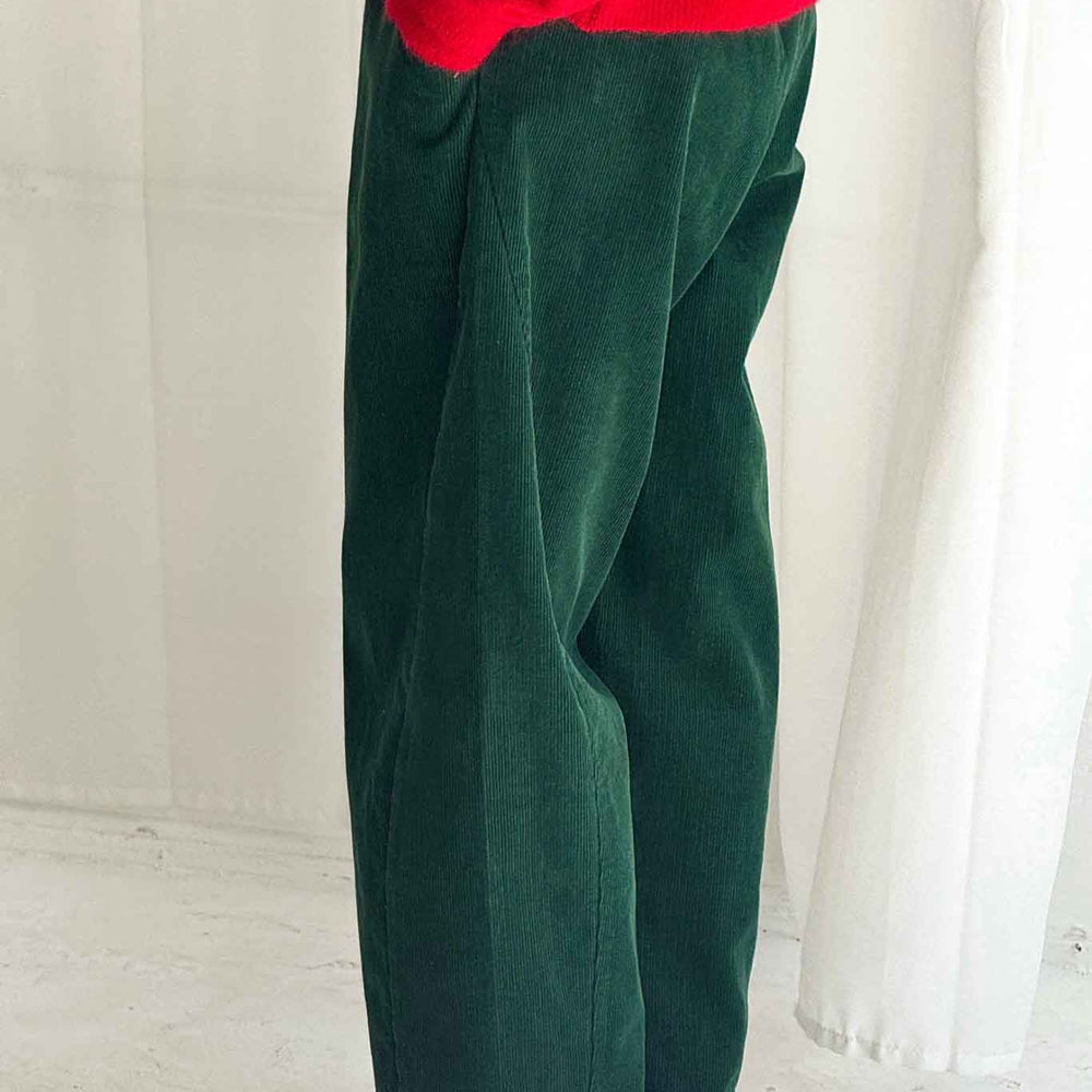 
                  
                    Person wearing green pants and a red top against a white background
                  
                