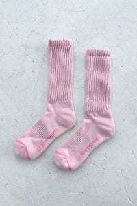 Pair of pink cotton socks on a light gray background