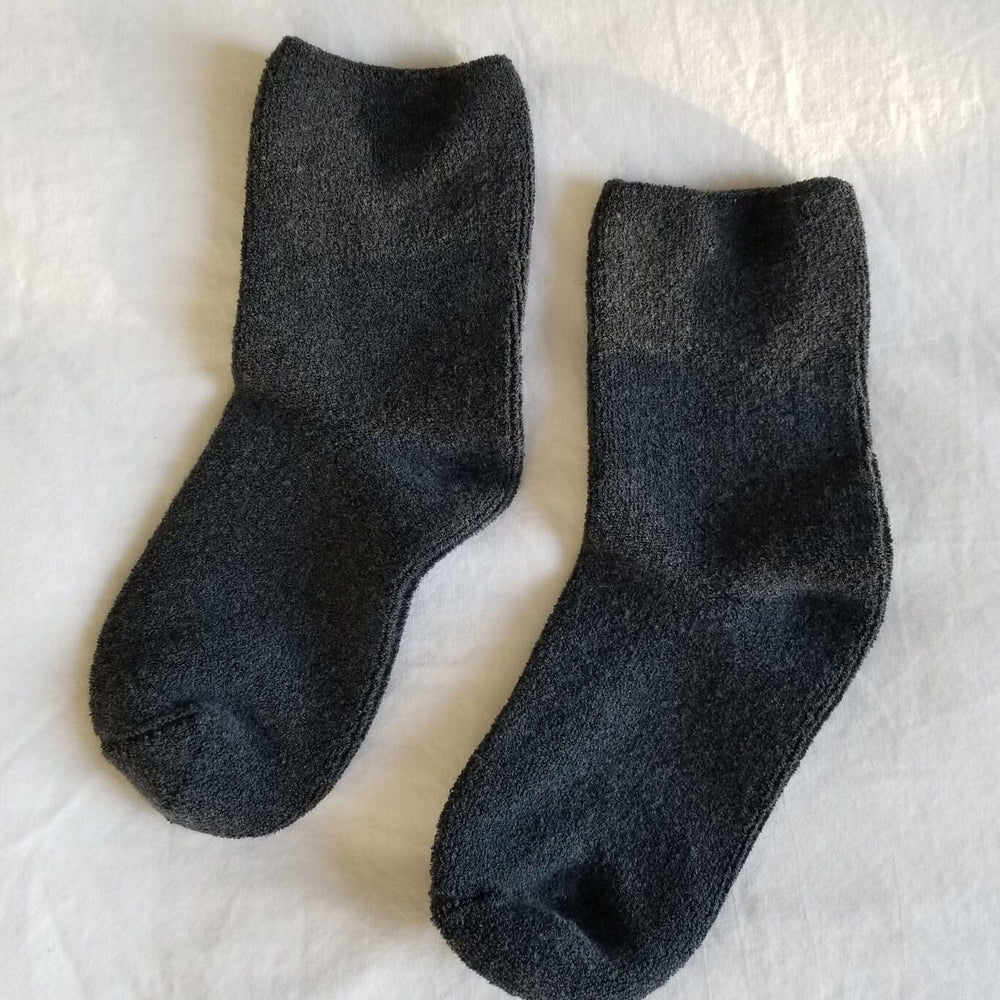 Pair of dark gray socks on a textured white surface