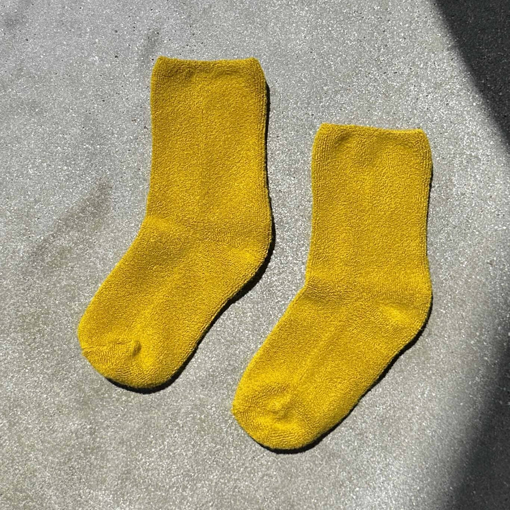 Pair of yellow socks on a gray surface