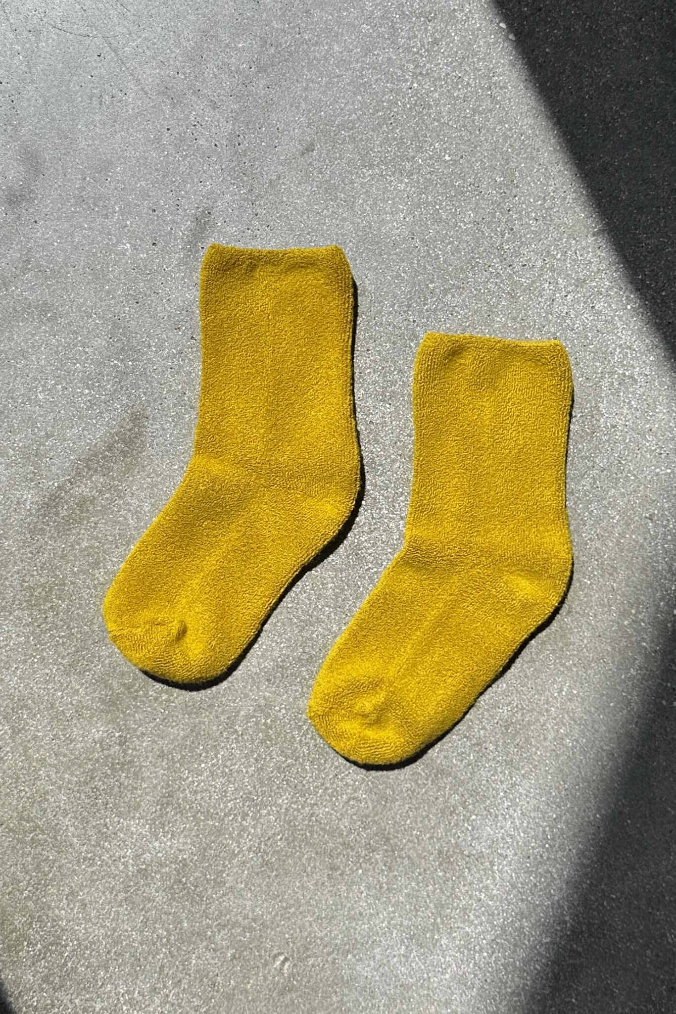Pair of yellow socks on a gray surface