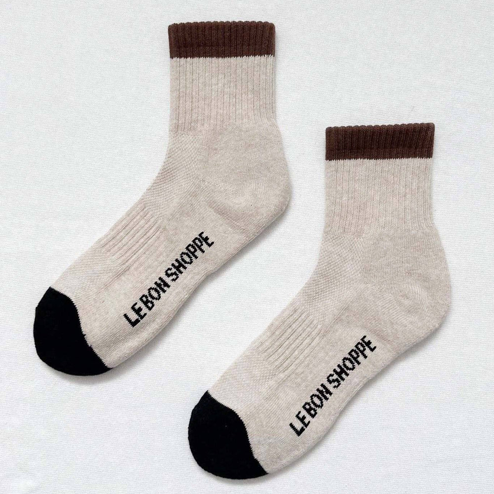 Pair of beige socks with brown accents and 'Le Bon Shoppe' branding on a light gray background