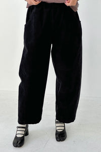 Person wearing black straight-leg pants on a white background