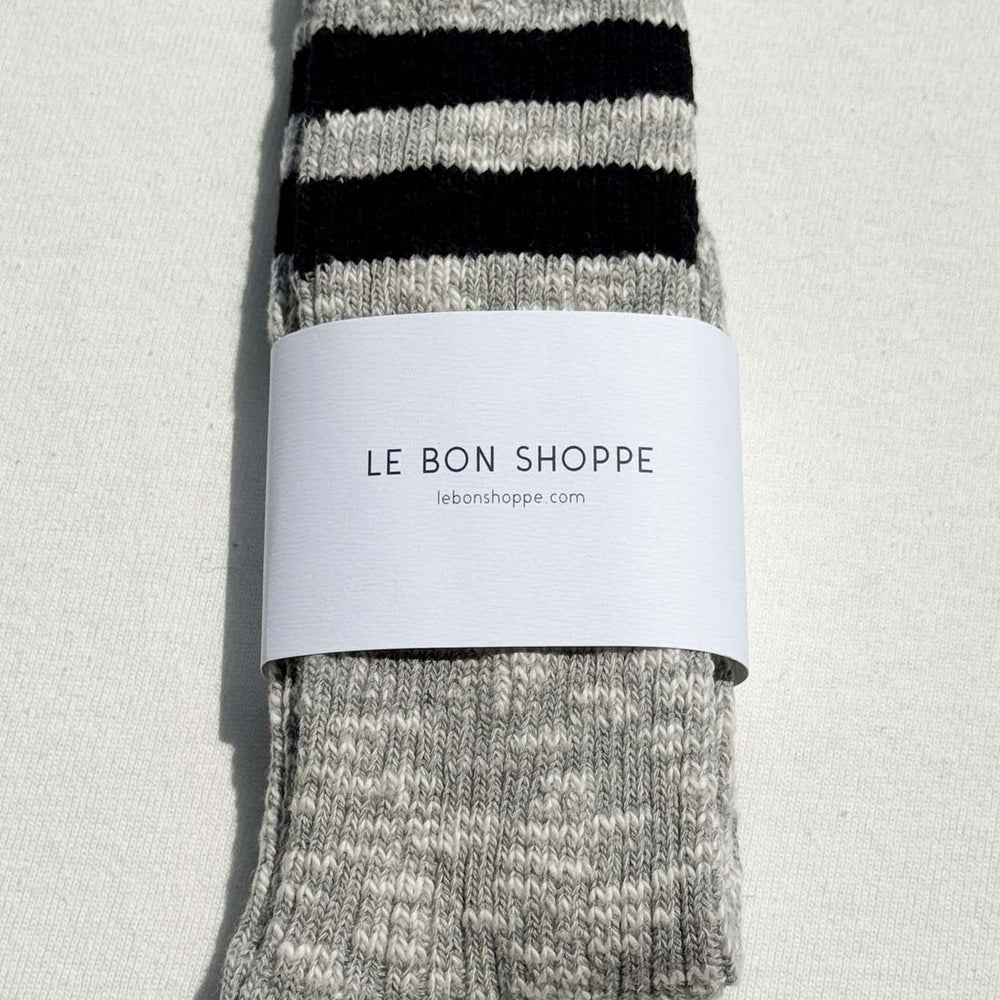 
                  
                    Gray socks with black stripes and a white label on a light gray background
                  
                