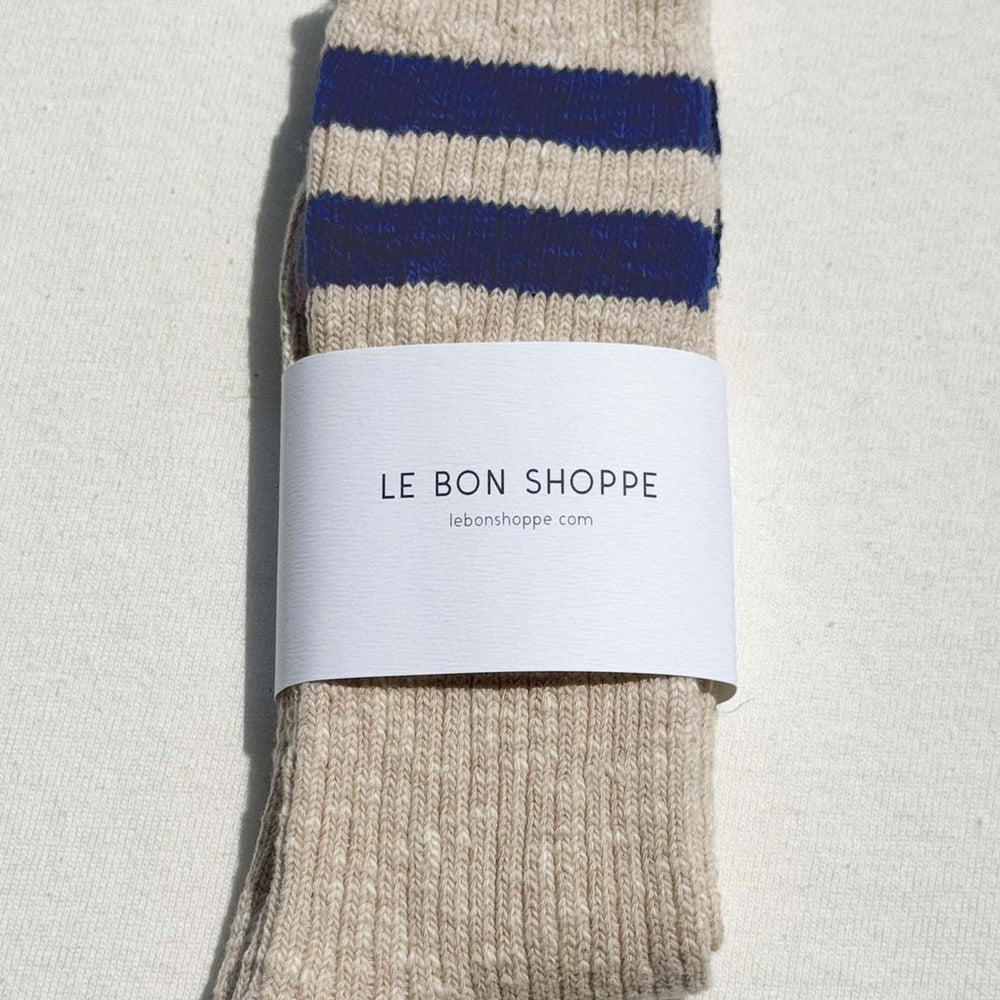 
                  
                    Pair of beige striped socks with a visible brand label on a light background
                  
                