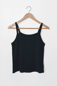 Black tank top on a wooden hanger against a white background