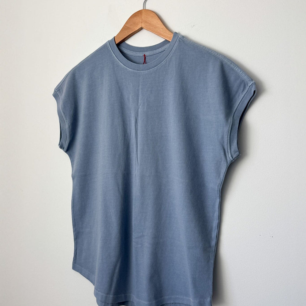 Blue sleeveless shirt on a wooden hanger against a light gray background