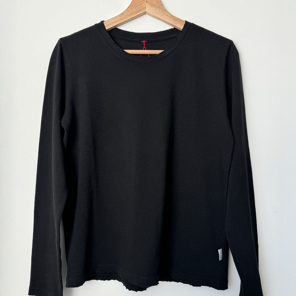Black long-sleeve shirt on a wooden hanger against a white background