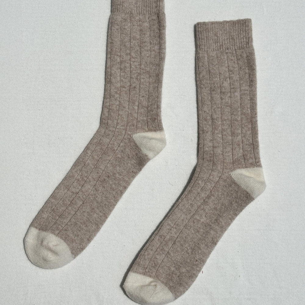 Pair of light brown and cream cashmere socks on a light gray background