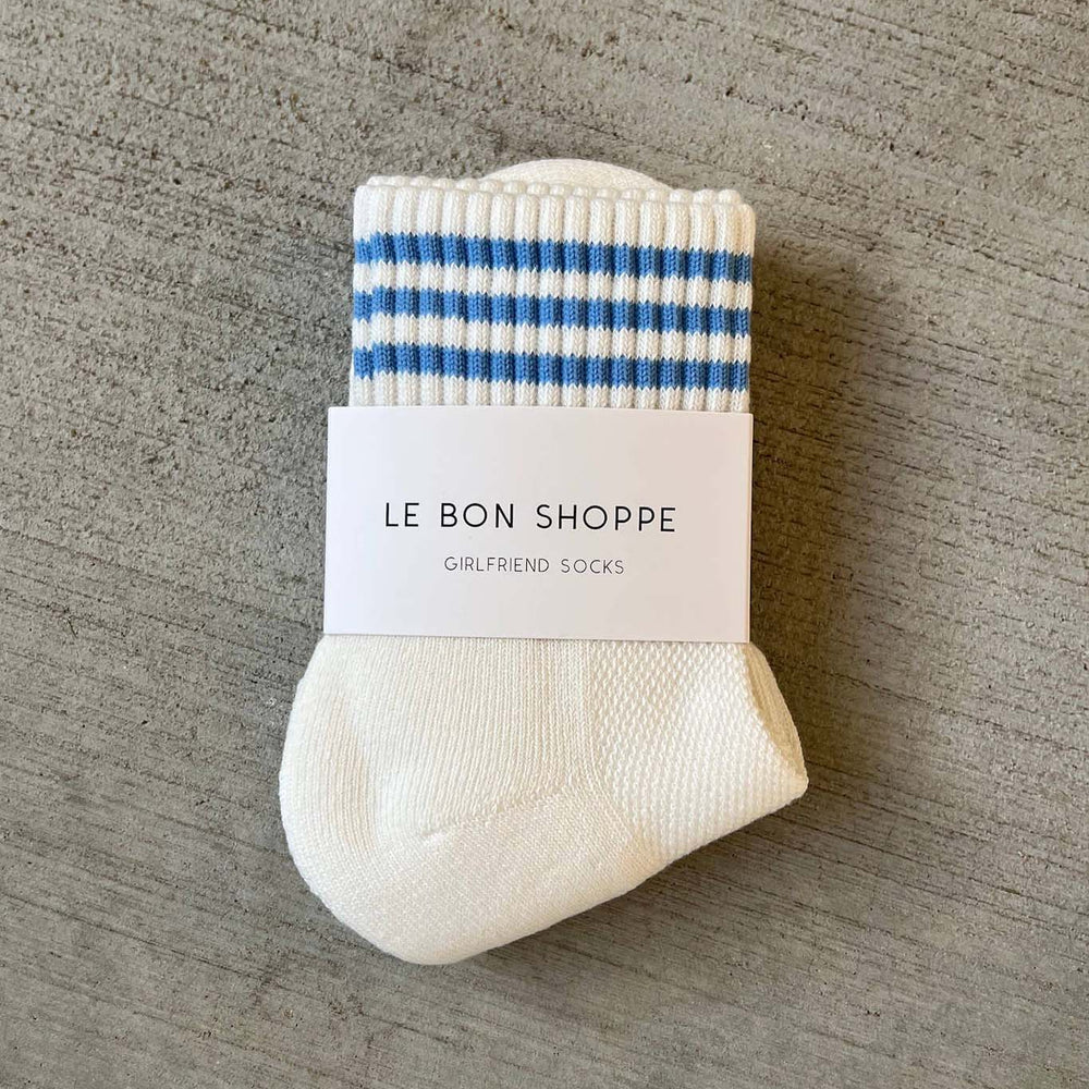 White sock with blue stripes and a label on a gray surface