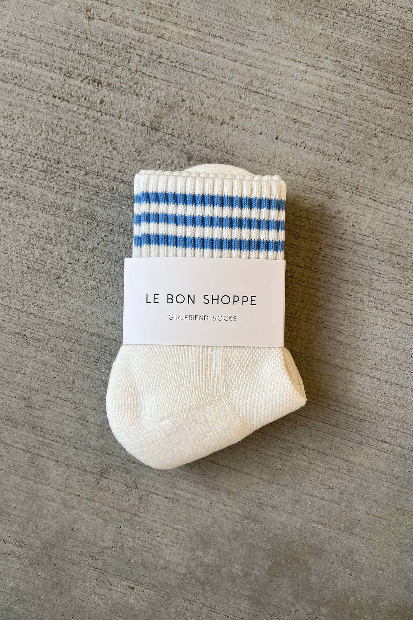 White sock with blue stripes and a label on a gray surface