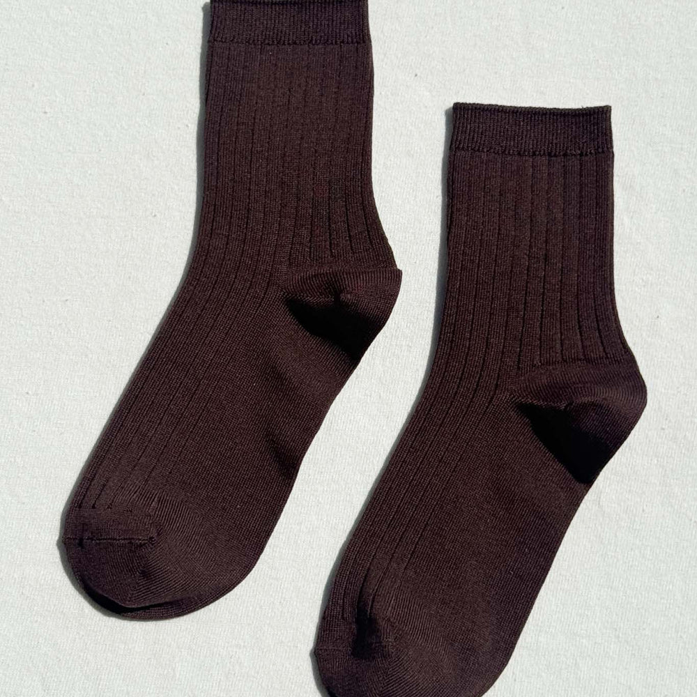 Pair of dark brown socks on a light gray background