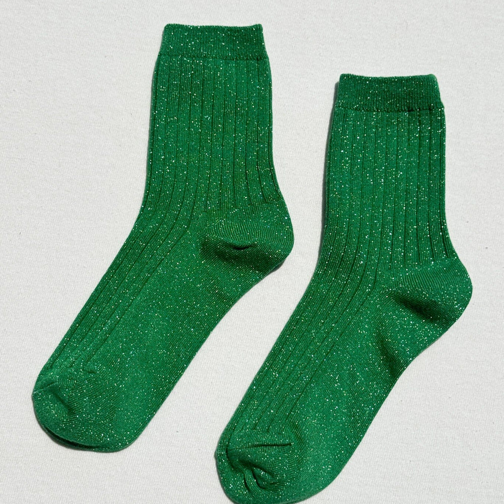 Pair of green sparkly socks on a light gray background