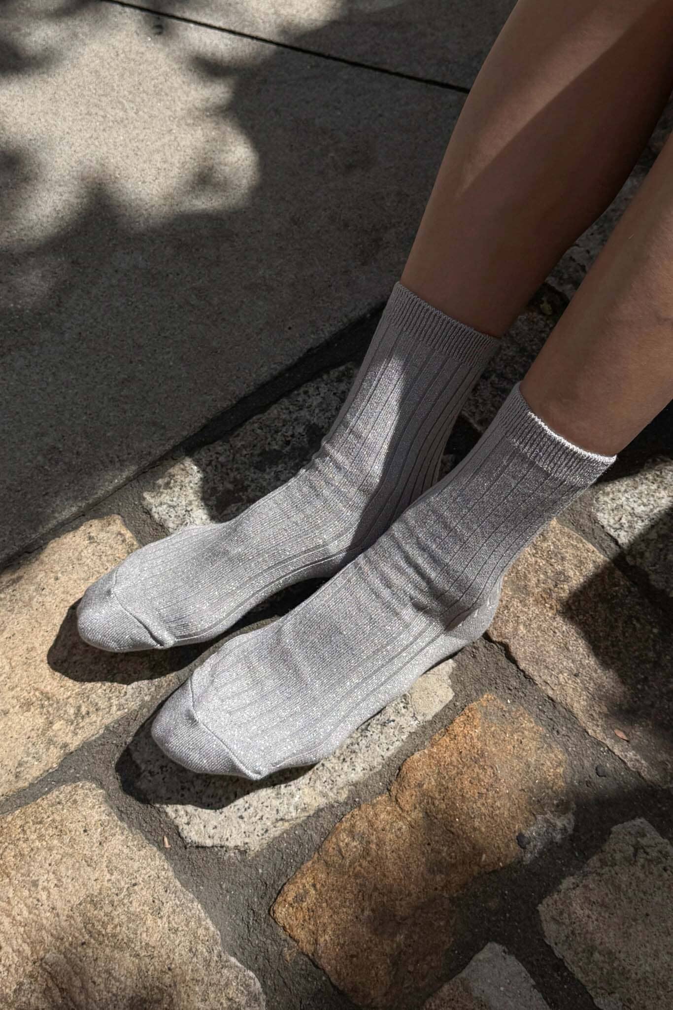 Gray socks worn on a stone pavement