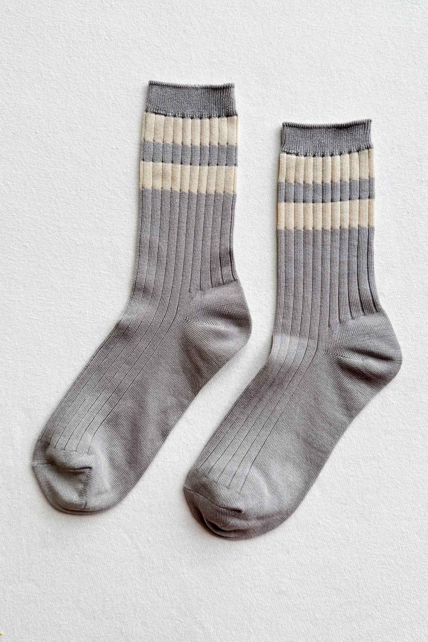 Pair of gray socks with beige stripes on a light gray background