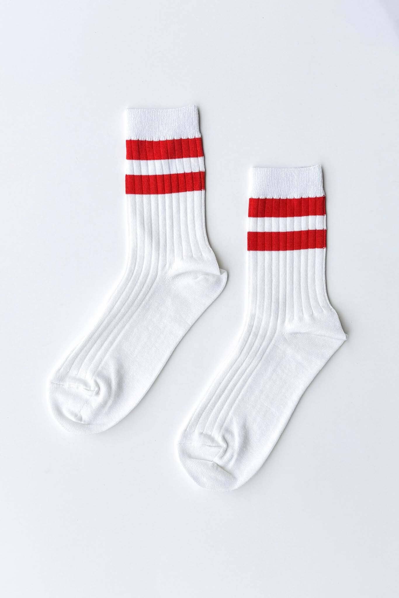 White socks with red and white stripes on a light gray background